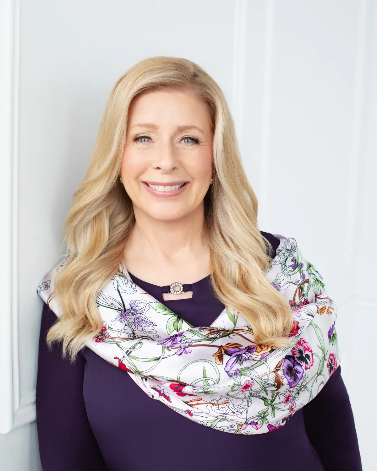 Portrait of author Amélie Jervay in a plum top and floral silk scarf